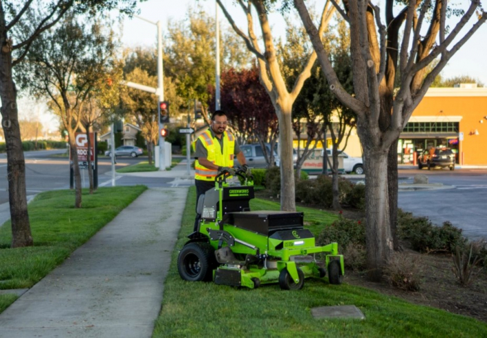 A Philco employee riding a lawn mower keeping a commercial clients landscaping clean