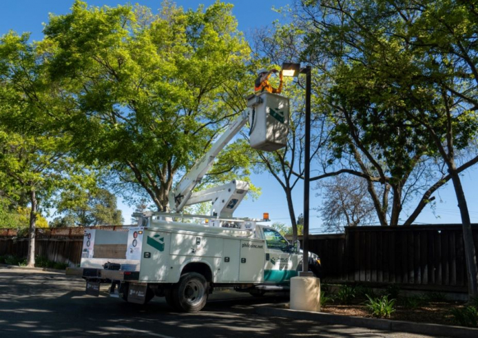 A Philco employee on a truck crane replacing a clients parking lot lighting