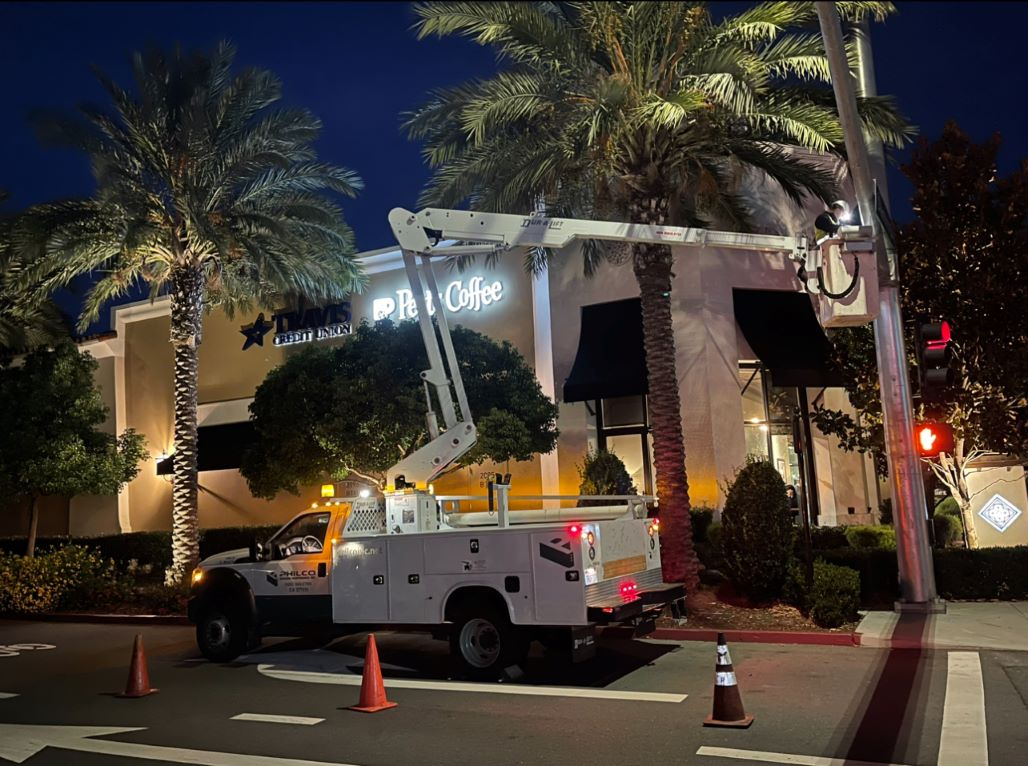 A Philco employee in a company trucks crane fixing a street lights electrical equipment