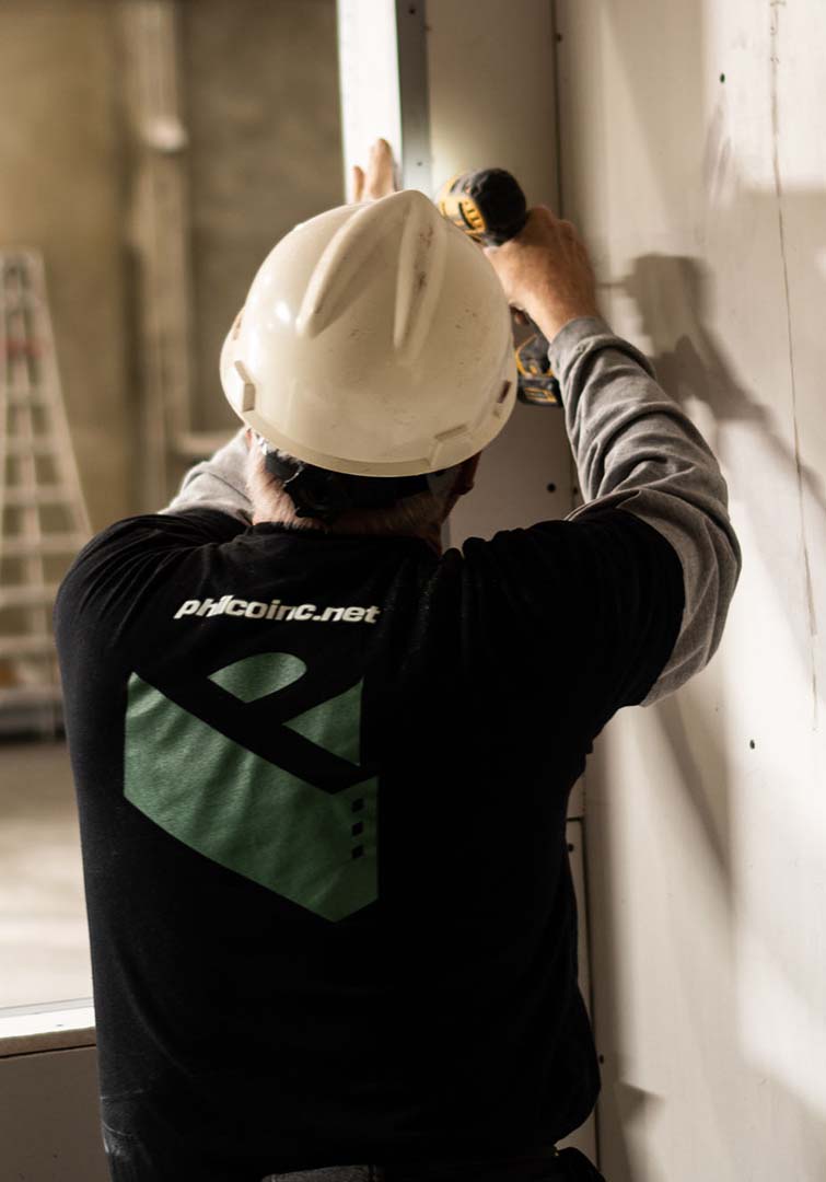 A Philco employee fixing siding on a wall