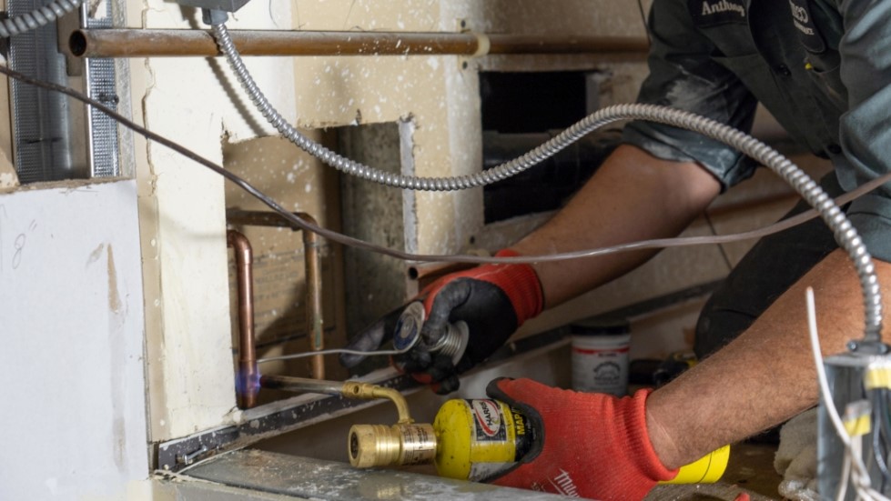 A Philco employee welding plumbing pipes for a new build client